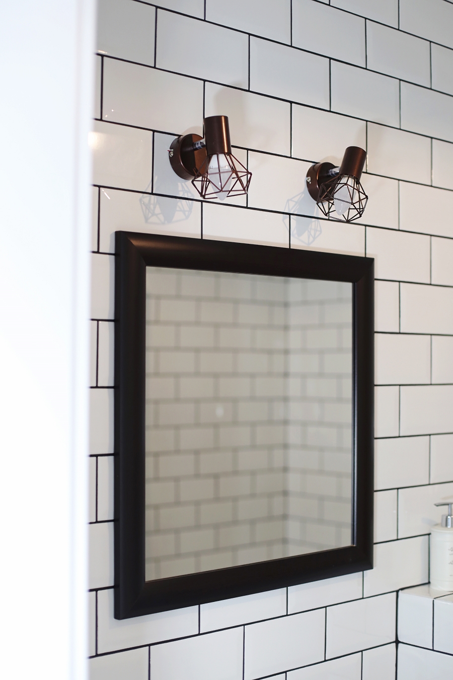Mała łazienka – lustro z drewnianą ramą, lampy
